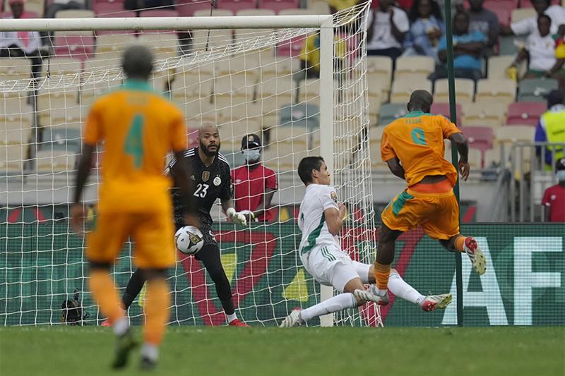 Ivory Coast s Franck Kessie, right, scores a goal as Algeria s Youcef Atal looks on during the Afric