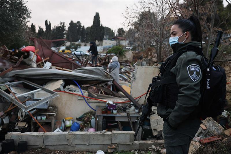  member of the Israeli forces stands by the ruins of a Palestinian house they demolished in Sheik Ja