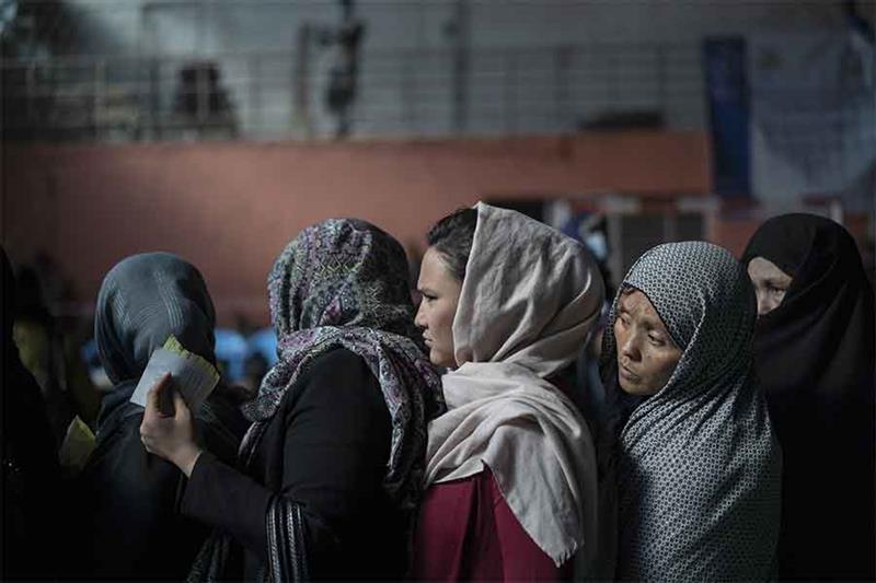 File photo:  People wait in queues to receive cash at a money distribution organized by the World Fo