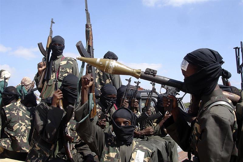 Armed al-Shabab fighters ride on pickup trucks as they prepare to travel into the city, just outside