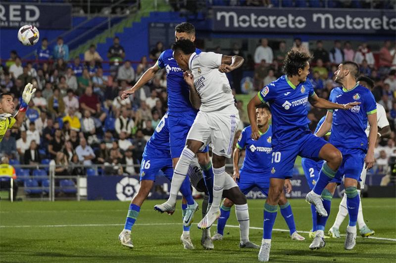 Real Madrid s Eder Militao, foreground, scores during La Liga soccer match between Getafe and Real M