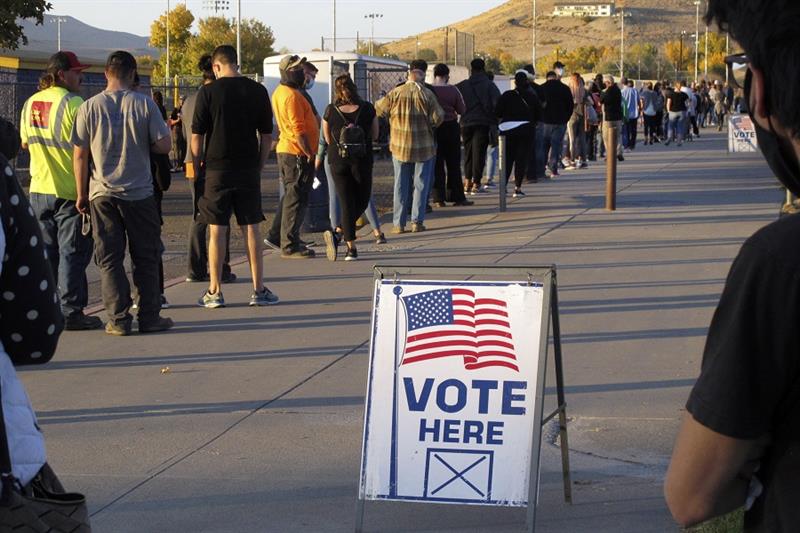 People wait to vote in-person at Reed High School in Sparks, Nev.