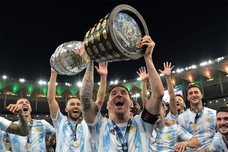 Argentina s Lionel Messi holds the trophy as he celebrates with teammates after winning the Conmebol
