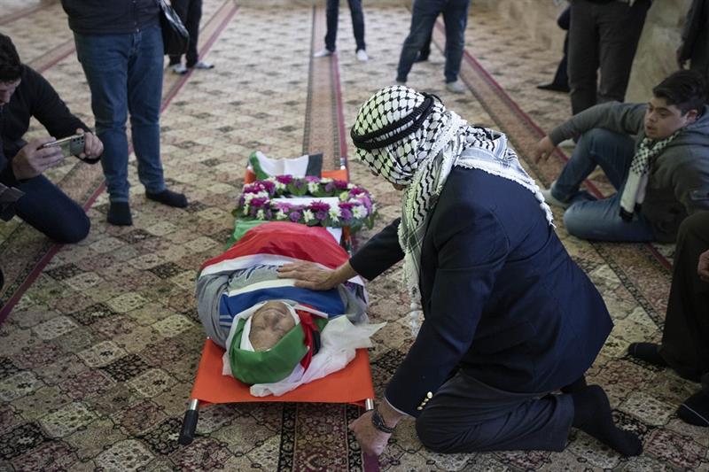 Mourners take a last look at the body of Omar Asaad, 78, during his funeral at a mosque in the West 