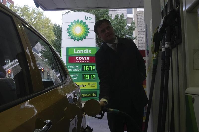 A man fills petrol to his car at a BP petrol station in London