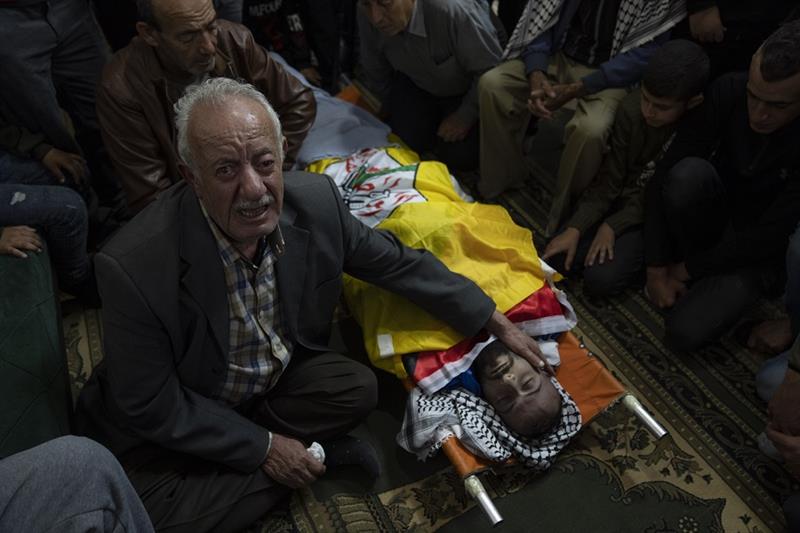 Palestinian Ali Ayaseh cries while he takes the last look at his son Rafat Ayaseh, 29, during his fu
