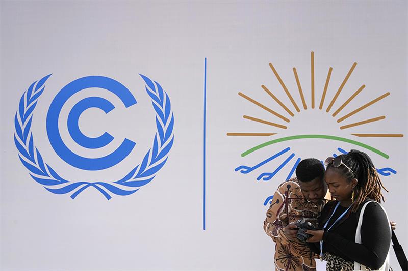 Attendees look at images that they shot at the COP27 U.N. Climate Summit, Monday, Nov. 14, 2022, in 