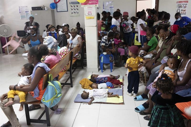 Babies sleep as their parents wait their turns to have them checked for symptoms of malnutrition at 