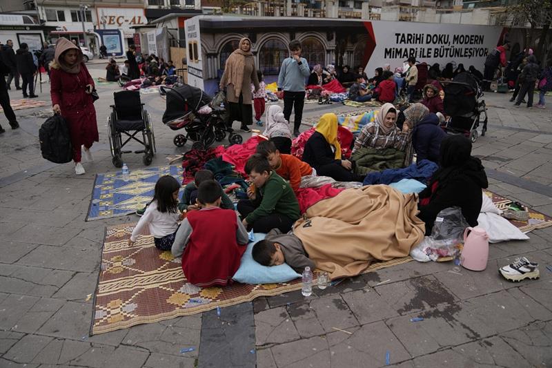 People rest outside their homes in Duzce, Turkey, Wednesday, Nov. 23, 2022, after a magnitude 5.9 ea