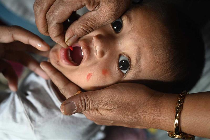 A health worker administers a vaccine to a child at a temporary vaccination camp following a measles