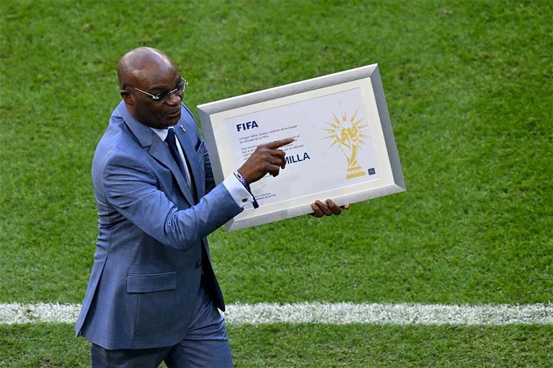 Former Cameroon football player Roger Milla holds an award presented by FIFA President Gianni Infant