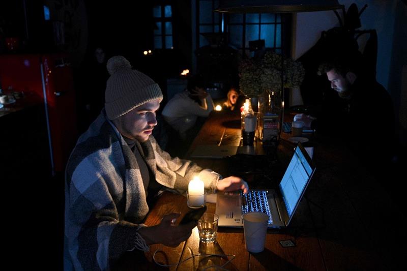 People rest in a coffee shop in Lviv as the city lives through a scheduled power outages