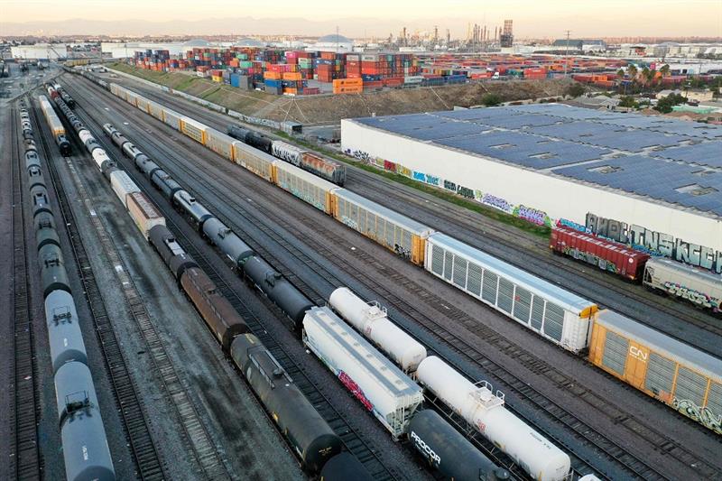 In an aerial view, freight rail cars sit in a rail yard near shipping containers on November 22, 202