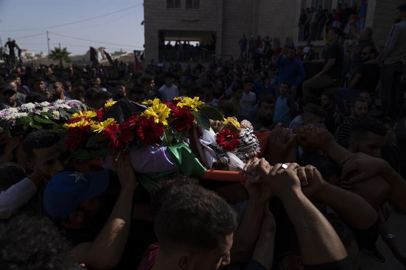Palestinian mourners carry the body of Musab Nofal, 18 during his funeral in the West Bank village o