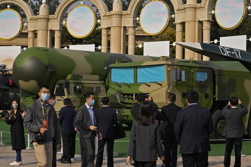 Visitors tour past military vehicles carrying the Dong Feng 41 and DF-17 ballistic missiles at an ex