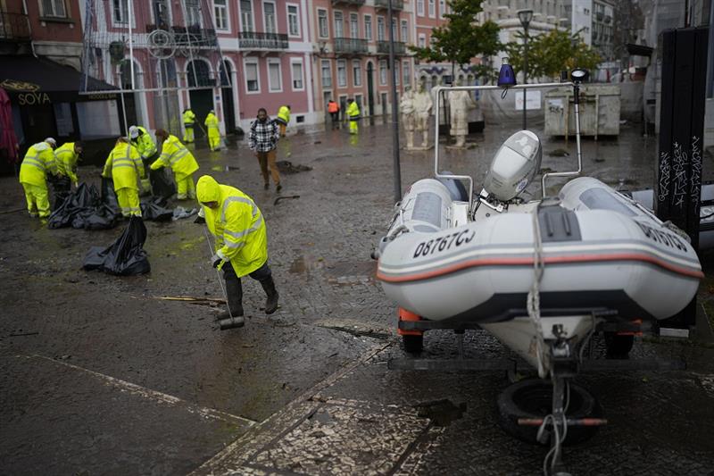 Municipal workers clean a street that was flooded overnight in Alges, just outside Lisbon