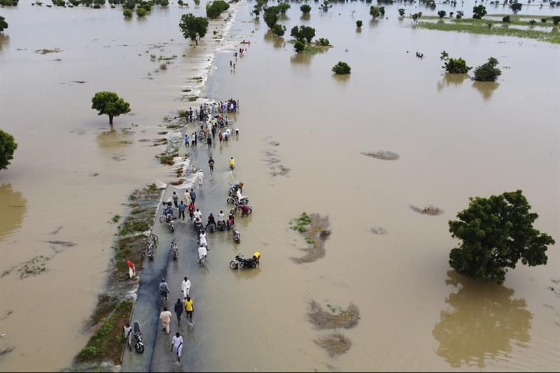 People walk through floodwaters after heavy rainfall in Hadeja, Nigeria