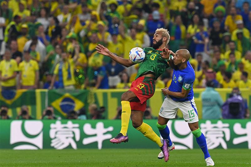 Cameroon s forward #13 Eric Maxim Choupo-Moting (L) fights for the ball with Brazil s midfielder #15