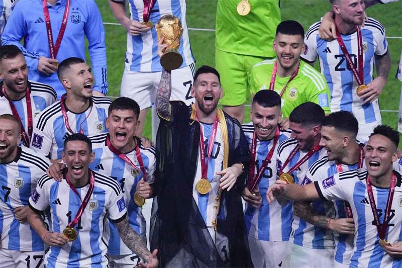 Argentina s Lionel Messi holds the trophy aloft as he celebrates with his team at the end of the Wor