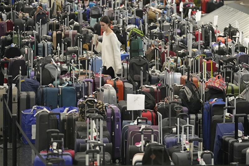 A woman walks through unclaimed bags at Southwest Airlines baggage claim at Salt Lake City Internati
