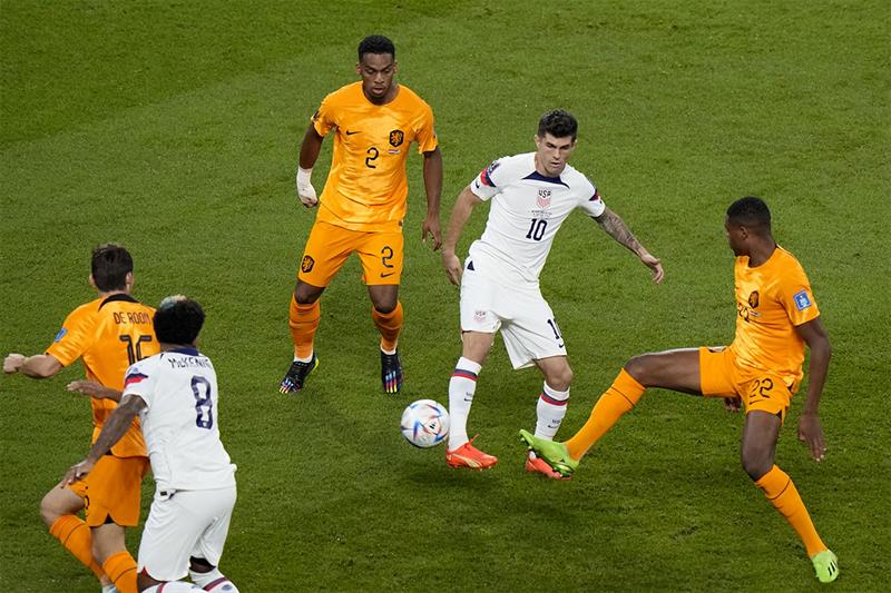 Denzel Dumfries of the Netherlands, right, tries to block a shot from Christian Pulisic of the Unite