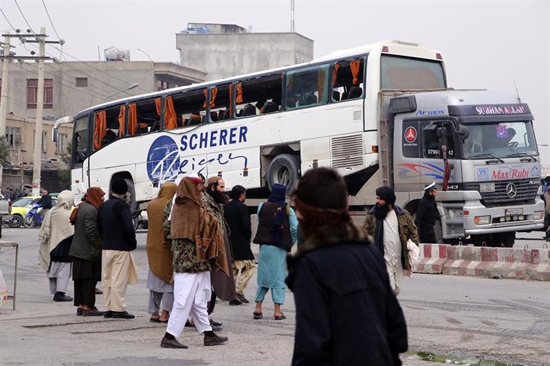 Taliban security personnel carry a damaged bus after a roadside bomb blast in Mazar-e Sharif
