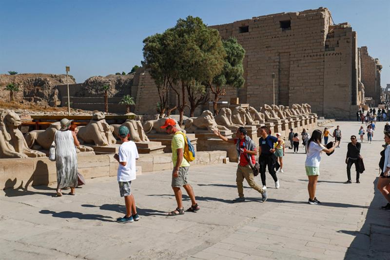 Visitors walk past the ram-headed sphinxes along the  Rams Road  (Sphinx dromos) near the Temple of 