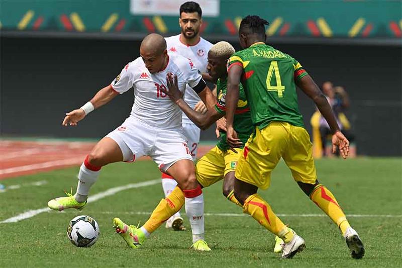 Tunisia s midfielder Ghailene Chaalali (L) fights for the ball with Mali s defender Falaye Sacko (C)