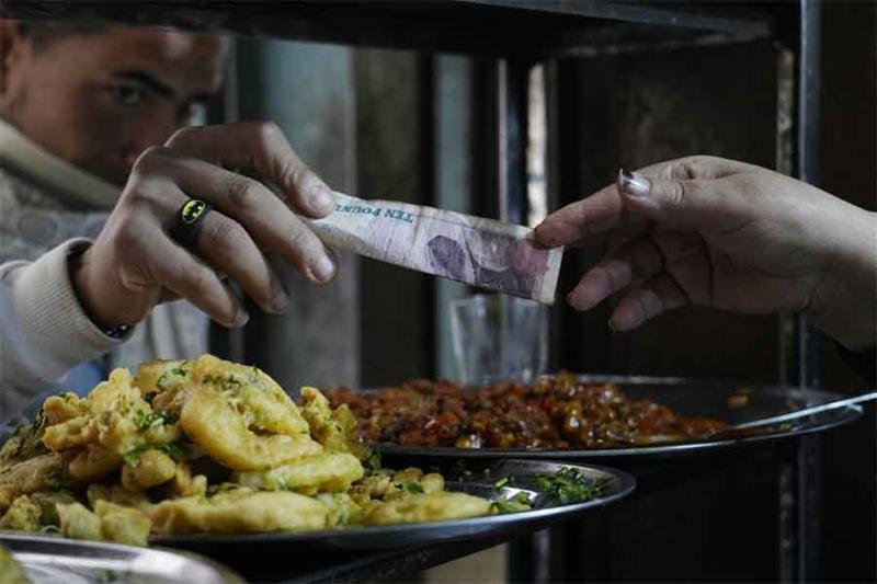 A man buys food at a popular restaurant in Cairo, Egypt, Tuesday, March 22, 2022. AFP