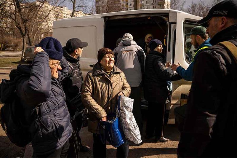 Refugees are helped out of a van after fleeing the combat zone in the suburbs of the Ukrainian capit
