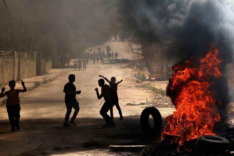 Palestinian children burn tyres following an earler an Israeli military raid in Jenin in the occupie