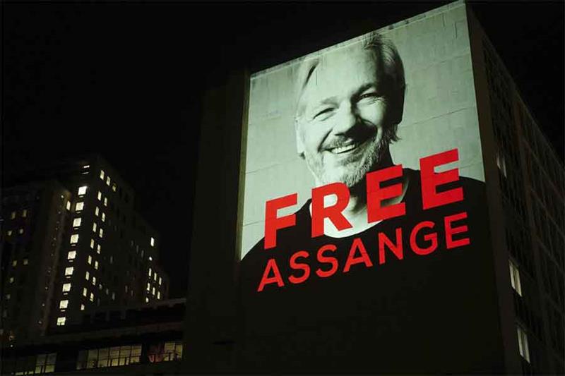 An image of Julian Assange is projected onto a building in Leake Street in central London on Sunday,