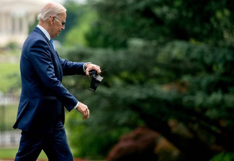 US President Joe Biden checks his watch as he walks to the Oval Office after disembarking Marine One