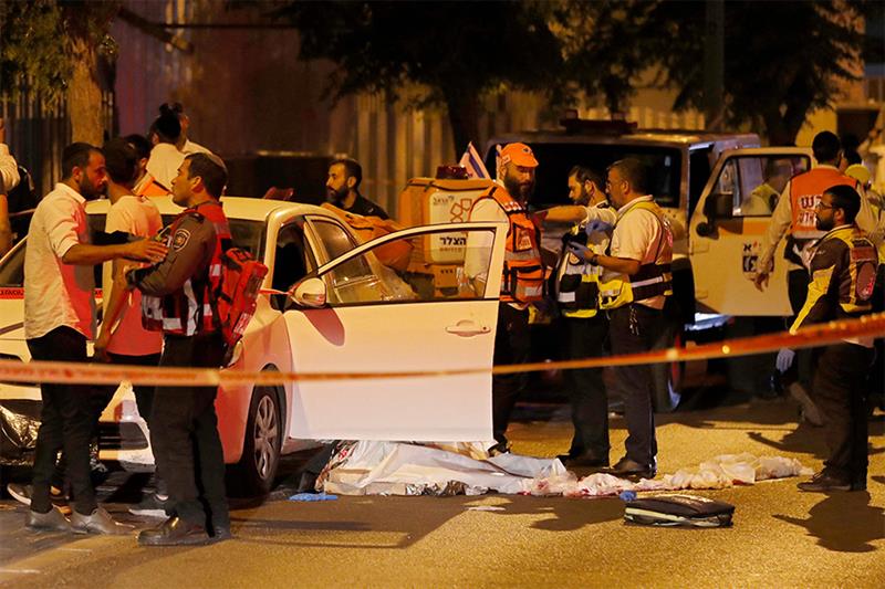 Israeli police and medics are pictured at the scene of an attack attack in the cetral city of Elad, 