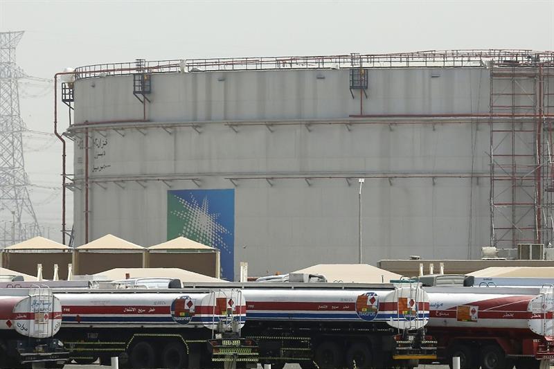 Fuel trucks line up in front of storage tanks, Saudi Arabia 