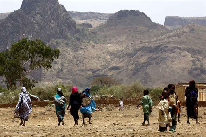 Sudanese villagers walk in the war-torn town of Golo in central Darfur.  AFP