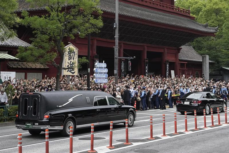 The vehicle, left, carrying the body of former Japanese Prime Minister Shinzo Abe