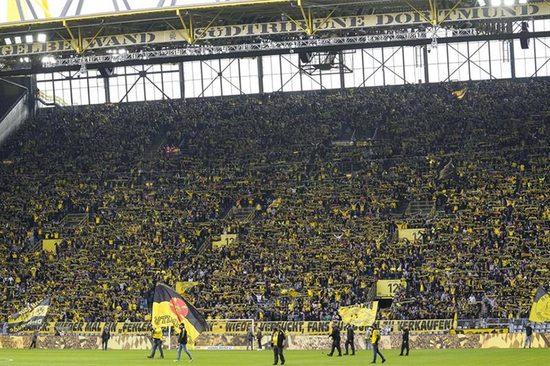 FILE - Borussia Dortmund fans stand singing on the southern tribune  yellow wall  prior to the Germa