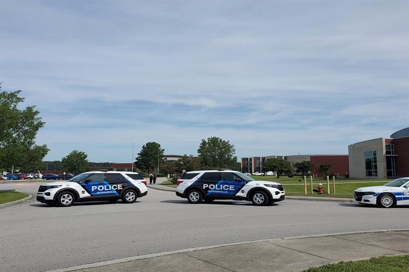 Police cruisers are seen at the site of a fatal stabbing at Northside High School in Jacksonville, N