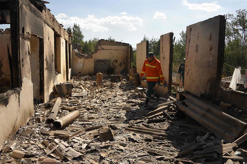 Firefighters work among the ruins of a house, which is said was hit by Azeri shelling during recent 