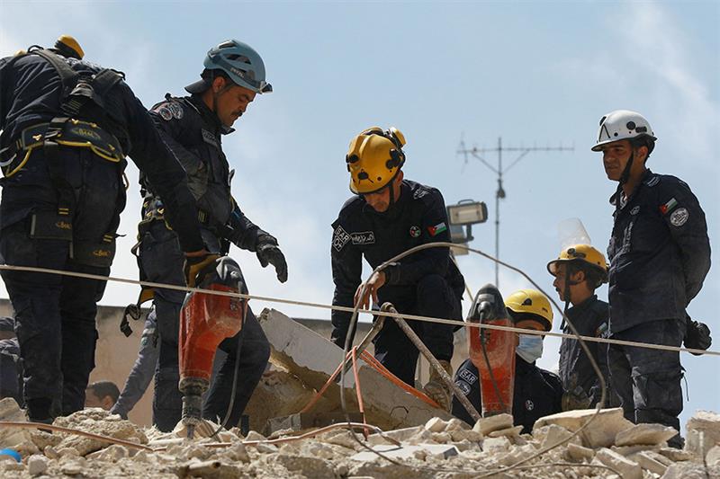 Jordanian rescue teams search for 10 people still missing under the rubble of a collapsed four-store