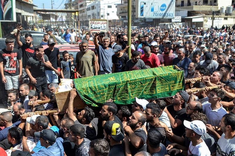Mourners march with the body of one of the victims who drowned in the shipwreck of a migrant boat