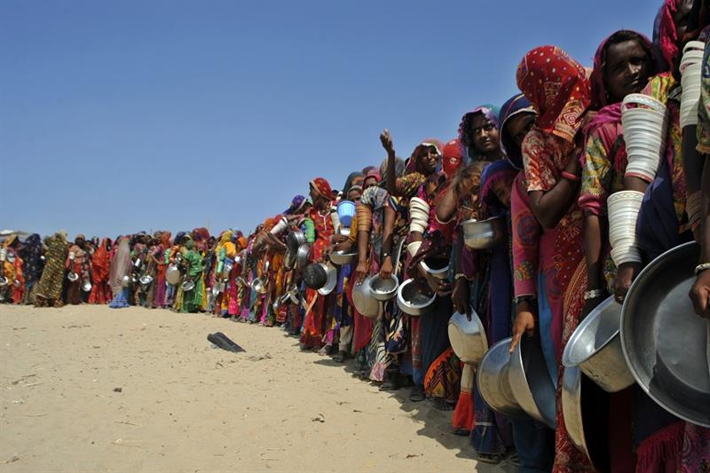 Women from flood-affected areas wait to get free food distributed by a charity, Sindh province, Paki