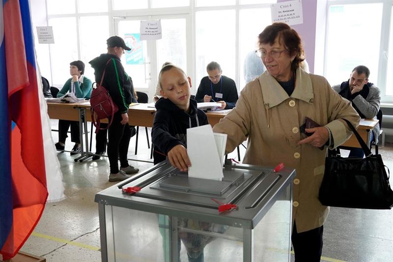 A woman casts her ballot for a referendum at a polling station in Mariupol 