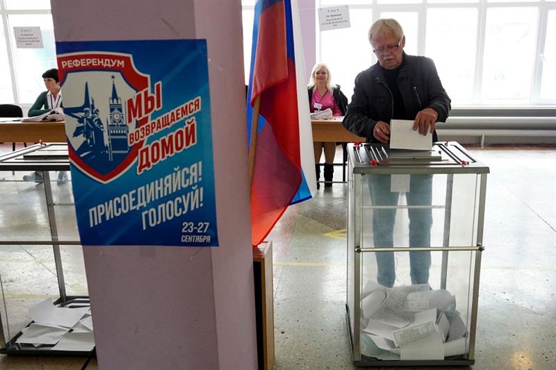 A man casts his ballot for a referendum at a polling station in Mariupol