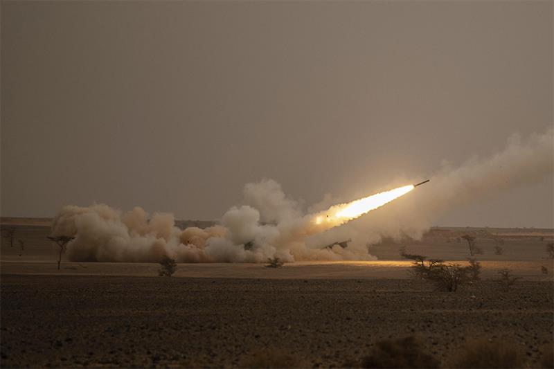 A launch truck fires the High Mobility Artillery Rocket System (HIMARS) at its intended target durin