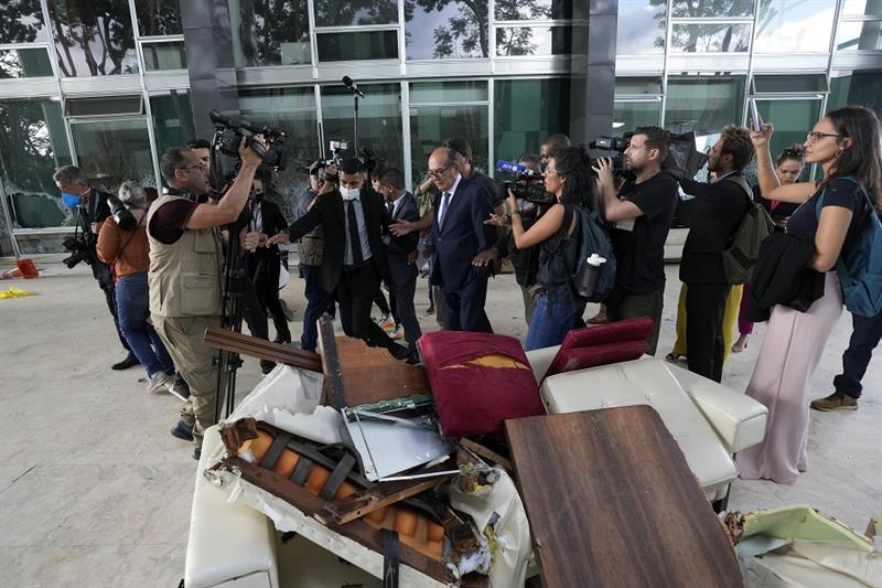 Supreme Court Justice Gilmar Mendes walks past a pile of furniture damaged by supporters of Brazil s