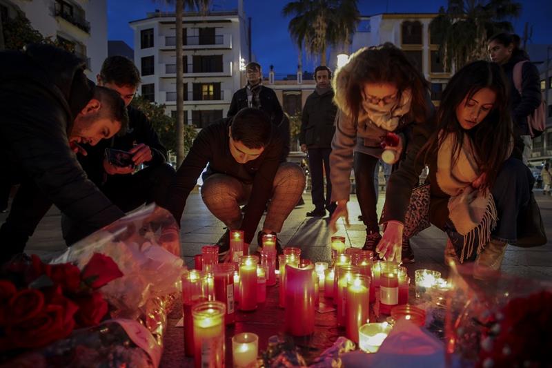 People light candles next to a memorial site for a church sacristan who was killed Wednesday in Alge