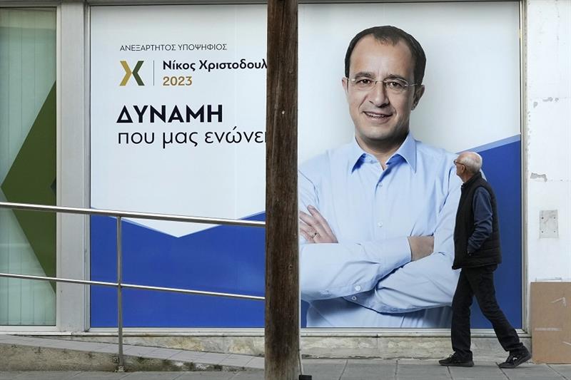 A man as walks past a poster of a presidential candidate campaign in Nicosia, Cyprus