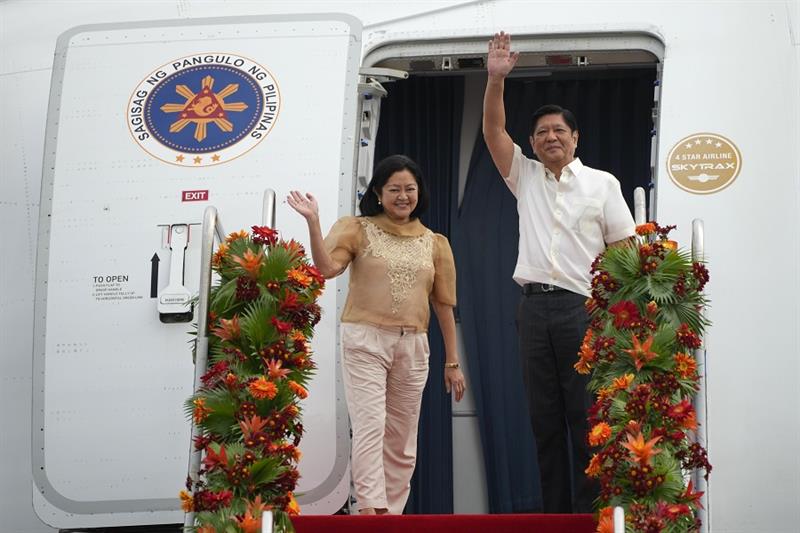 Philippine President Ferdinand Marcos Jr., right, waves beside wife Maria Louise as they board a pla